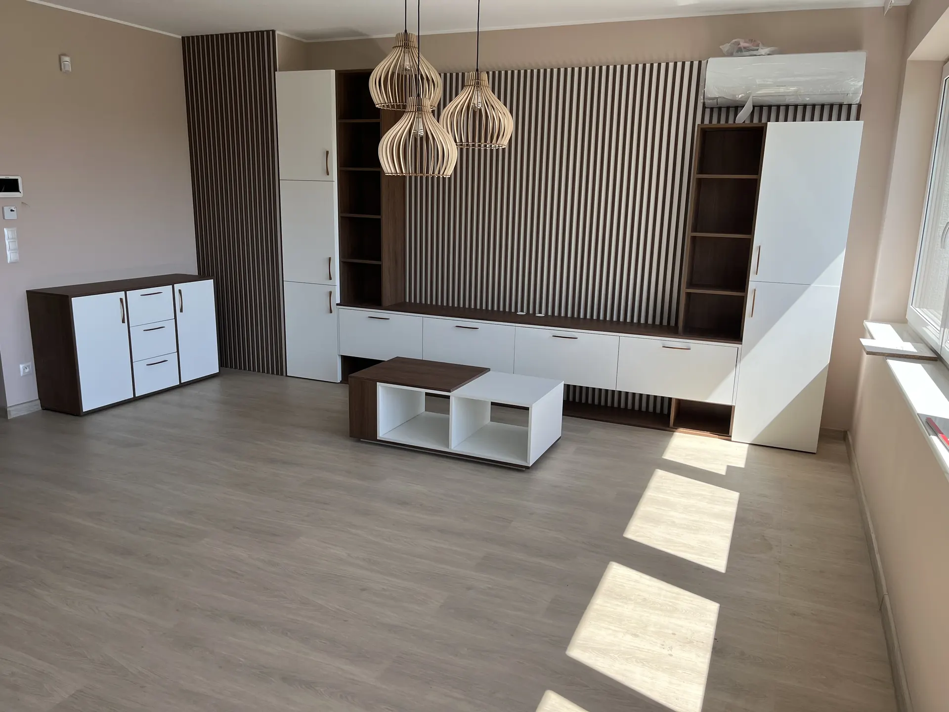 Meble do salonu Katowice – biała zabudowa RTV z drewnianymi panelami